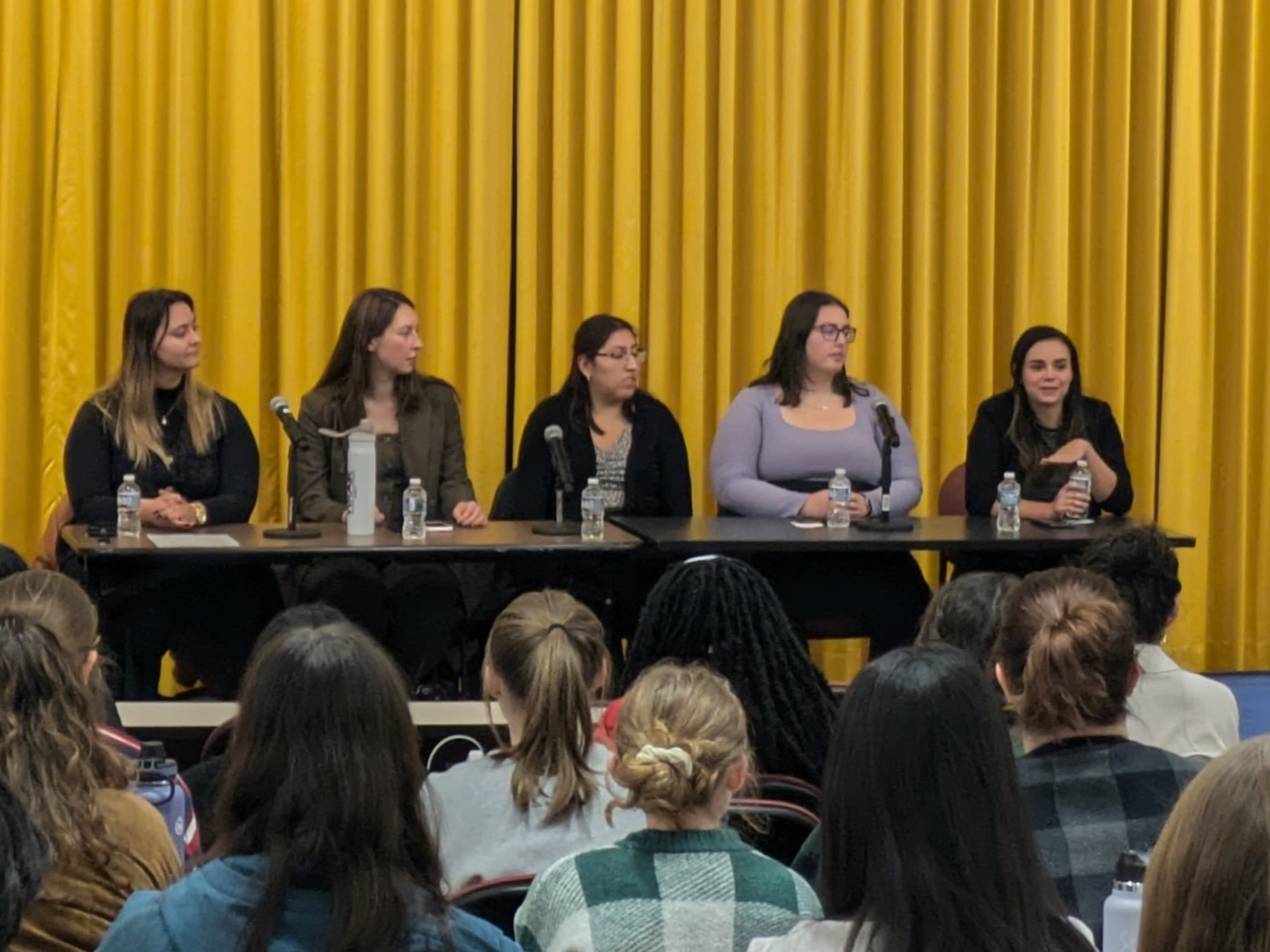 Five people sitting at a table facing an audience